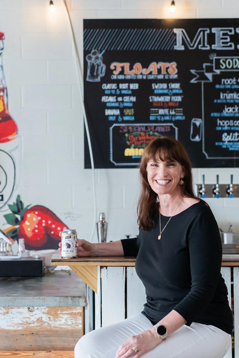 Woman enjoying a root beer at the New Creation Soda Works factory.